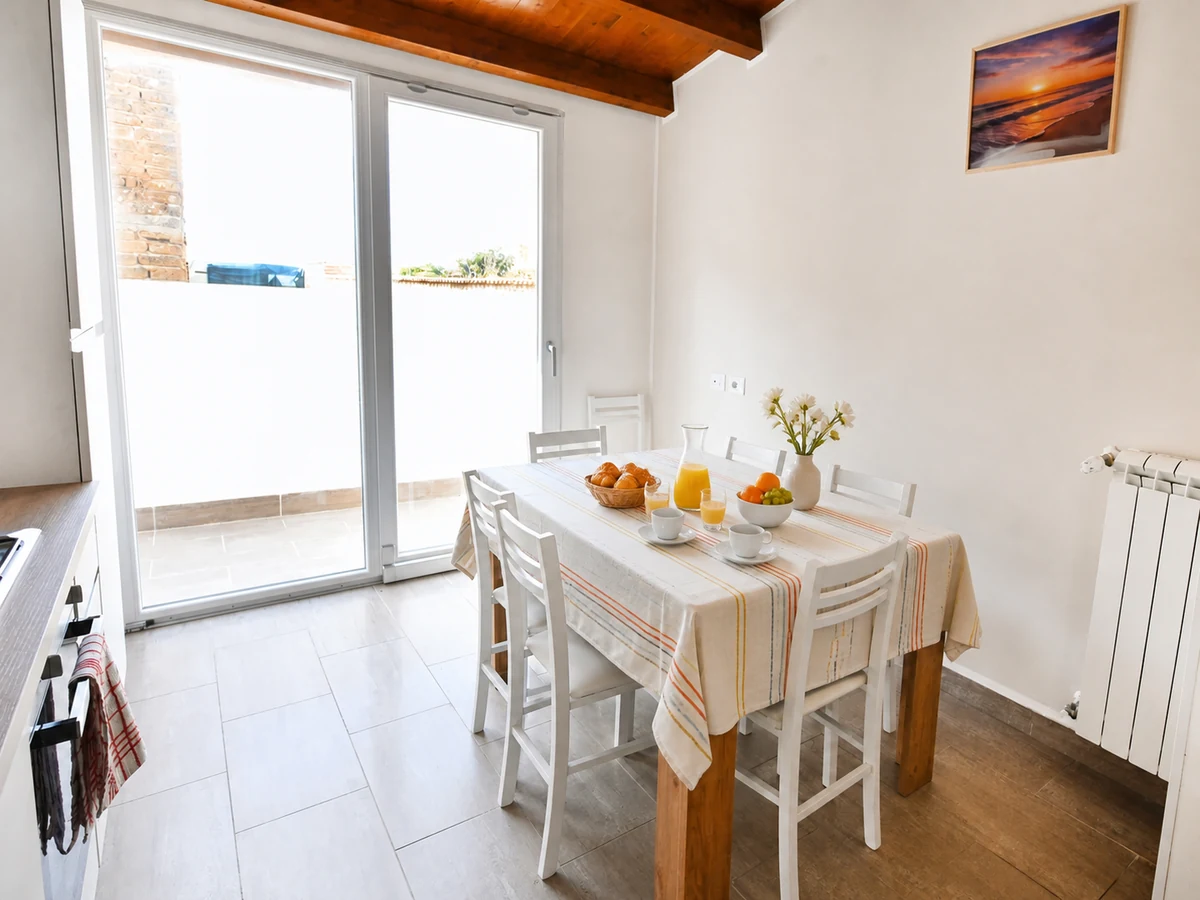 Bright Grecale dining area set for breakfast with access to the outdoor space