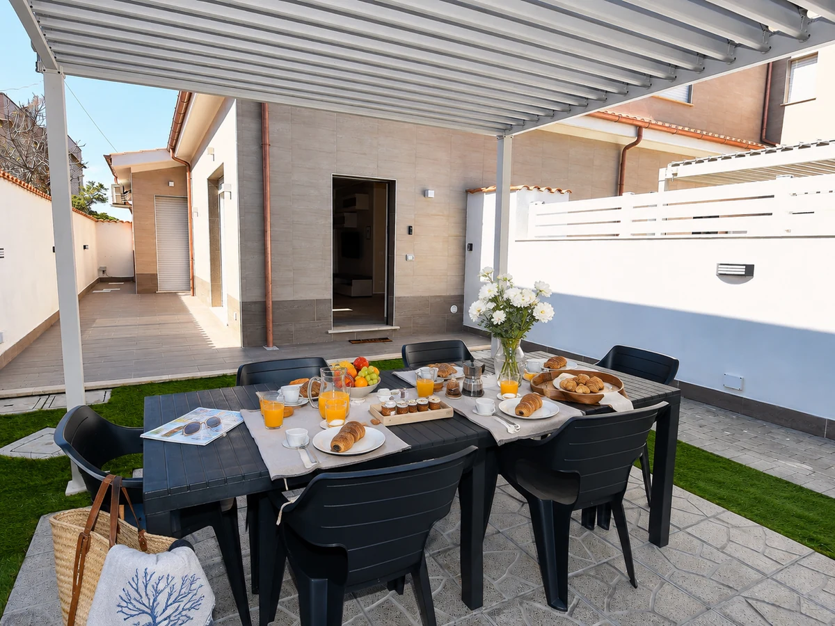 Breakfast table set in Ponente's garden under the pergola